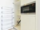 Modern kitchen with white cabinetry and built-in microwave oven