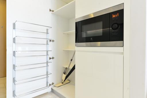 Modern kitchen with white cabinetry and built-in microwave oven