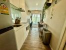 Modern kitchen interior with wooden floors leading to a well-lit dining area