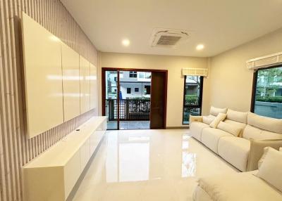 Spacious and well-lit living room with modern furnishings and glossy tiled flooring
