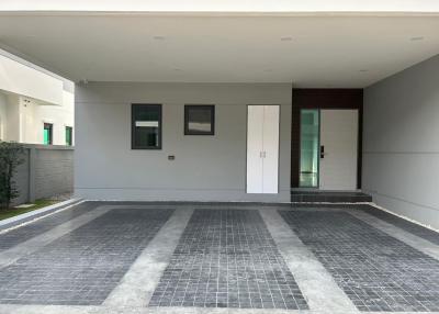 Modern house front with paved driveway and white entrance door