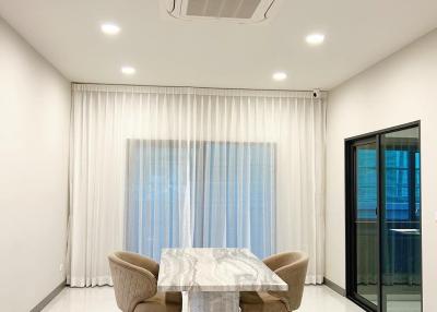 Modern dining room interior with white walls, ceiling lights, and large window