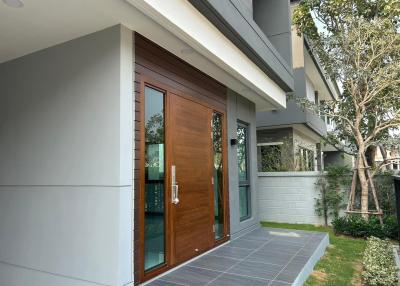 Modern house exterior with wooden front door and clean landscaping