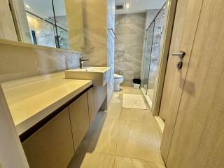 Modern bathroom interior with marble tiles and glass shower door