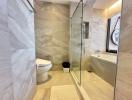 Modern bathroom with marble tiles and glass shower enclosure