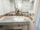 Modern bathroom with tiled flooring, granite countertop, and a large mirror