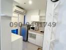 Compact modern kitchen with white cabinetry and appliances