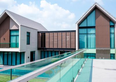 Modern twin residential buildings with a transparent bridge and swimming pool