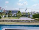 Modern suburban house with a spacious green lawn, outdoor swimming pool, and clear blue sky