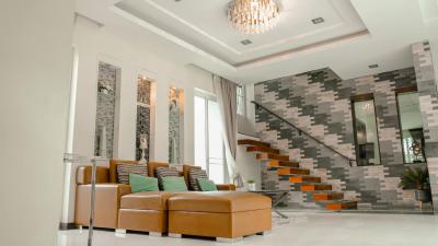 Spacious and modern living room with high ceiling and elegant staircase
