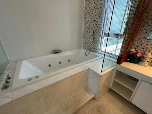 Modern bathroom interior with a large bathtub, glass shower, and elegant tiling