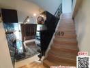 View of a stylish stairway inside a modern home with peek of living room area