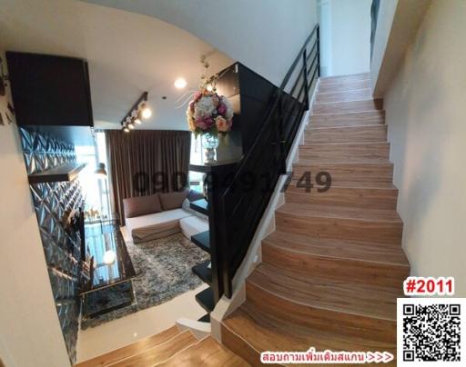 View of a stylish stairway inside a modern home with peek of living room area