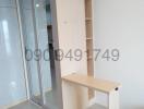 Compact room with a built-in wooden shelf and desk