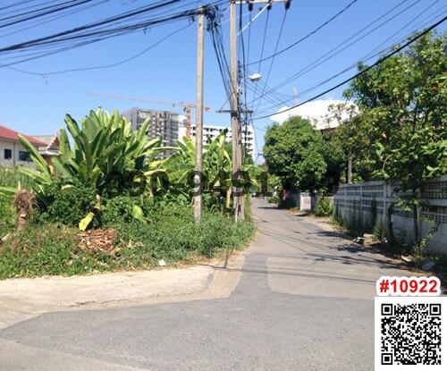 Exterior street view near residential area with buildings in the background and lush greenery