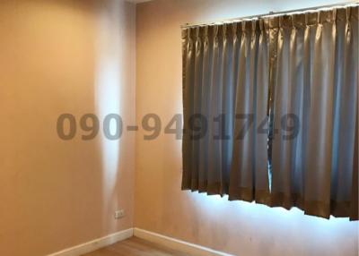 Empty bedroom with hardwood floors and grey curtains