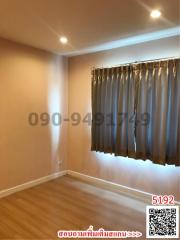 Empty bedroom with hardwood floors and grey curtains