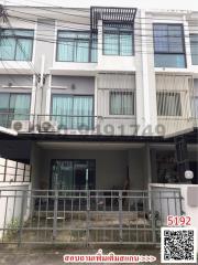 Modern three-story residential building with balcony and secure entrance