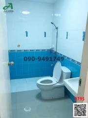 Compact bathroom with blue tile walls and white fixtures