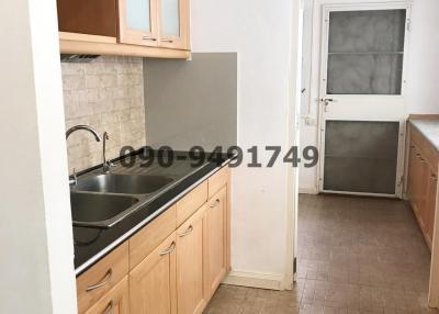 Compact kitchen with wooden cabinets and tile flooring