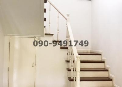 Elegant white staircase with wooden steps inside a home