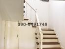 Elegant white staircase with wooden steps inside a home