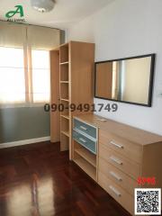 Compact bedroom with wooden furniture and ample natural light