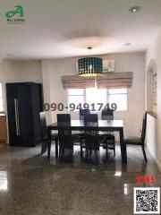 Spacious dining room with large table and refrigerator