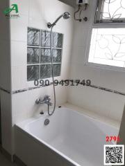 White tiled bathroom with bathtub and shower