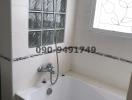 White tiled bathroom with bathtub and shower