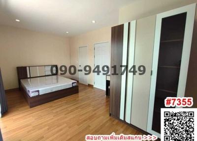 Spacious bedroom with wooden flooring, large bed, and wardrobes