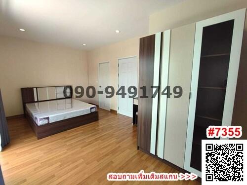 Spacious bedroom with wooden flooring, large bed, and wardrobes