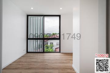 Bright bedroom with large window and wooden floor