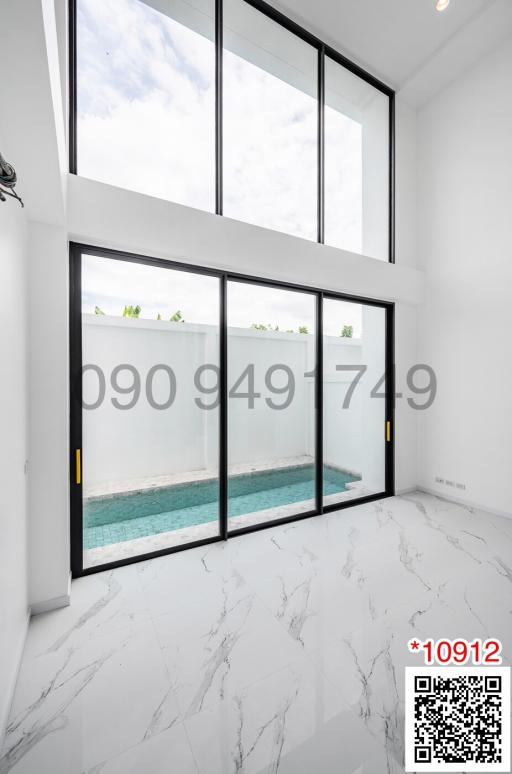 Modern living area with large windows and view of an outdoor pool