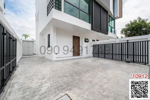 Modern two-story building with spacious driveway and secure gate