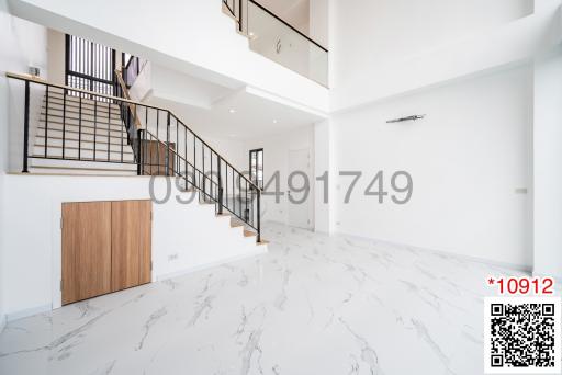 Bright and spacious interior with staircase and marble flooring