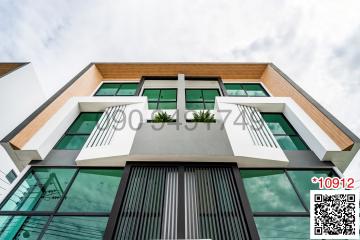 Modern building exterior with green plants and a stylish front