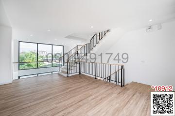 Spacious and well-lit living room with staircase and balcony