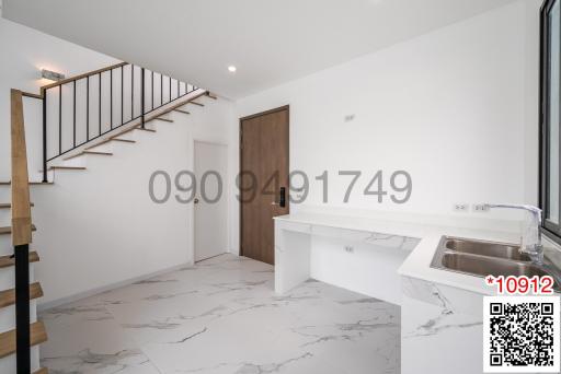 Modern kitchen with marble flooring and wooden staircase