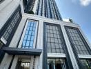 Modern high-rise residential building with ornate facade and geometric patterns on the approach