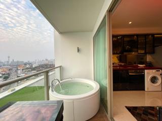 Spacious balcony with a jacuzzi, view of the city, and laundry area