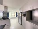 Modern kitchen with stainless steel appliances and white storage cabinets