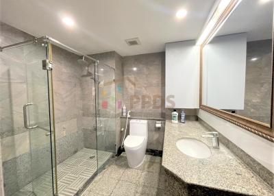 Modern bathroom with glass shower enclosure and granite countertops