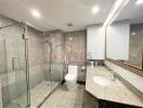 Modern bathroom with glass shower enclosure and granite countertops