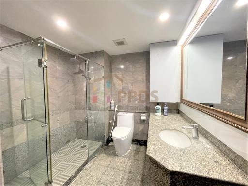 Modern bathroom with glass shower enclosure and granite countertops