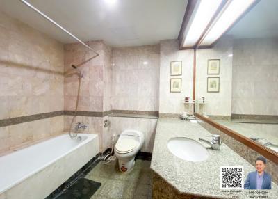 Spacious bathroom with modern amenities and marble tiles