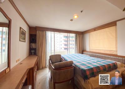 Spacious bedroom with large windows and comfortable furnishings