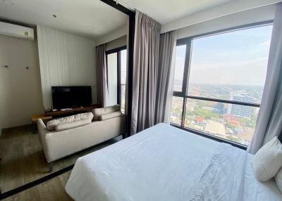 Modern bedroom with large window providing city views