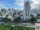 Panoramic city view with river and passing boat from high-rise apartment balcony
