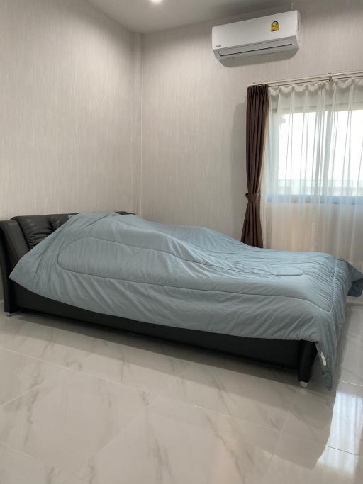 Spacious bedroom with large bed and modern air conditioning unit